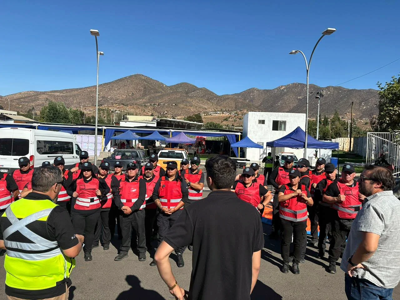 Formación de guardias de seguridad con chalecos reflectantes frente a cerros