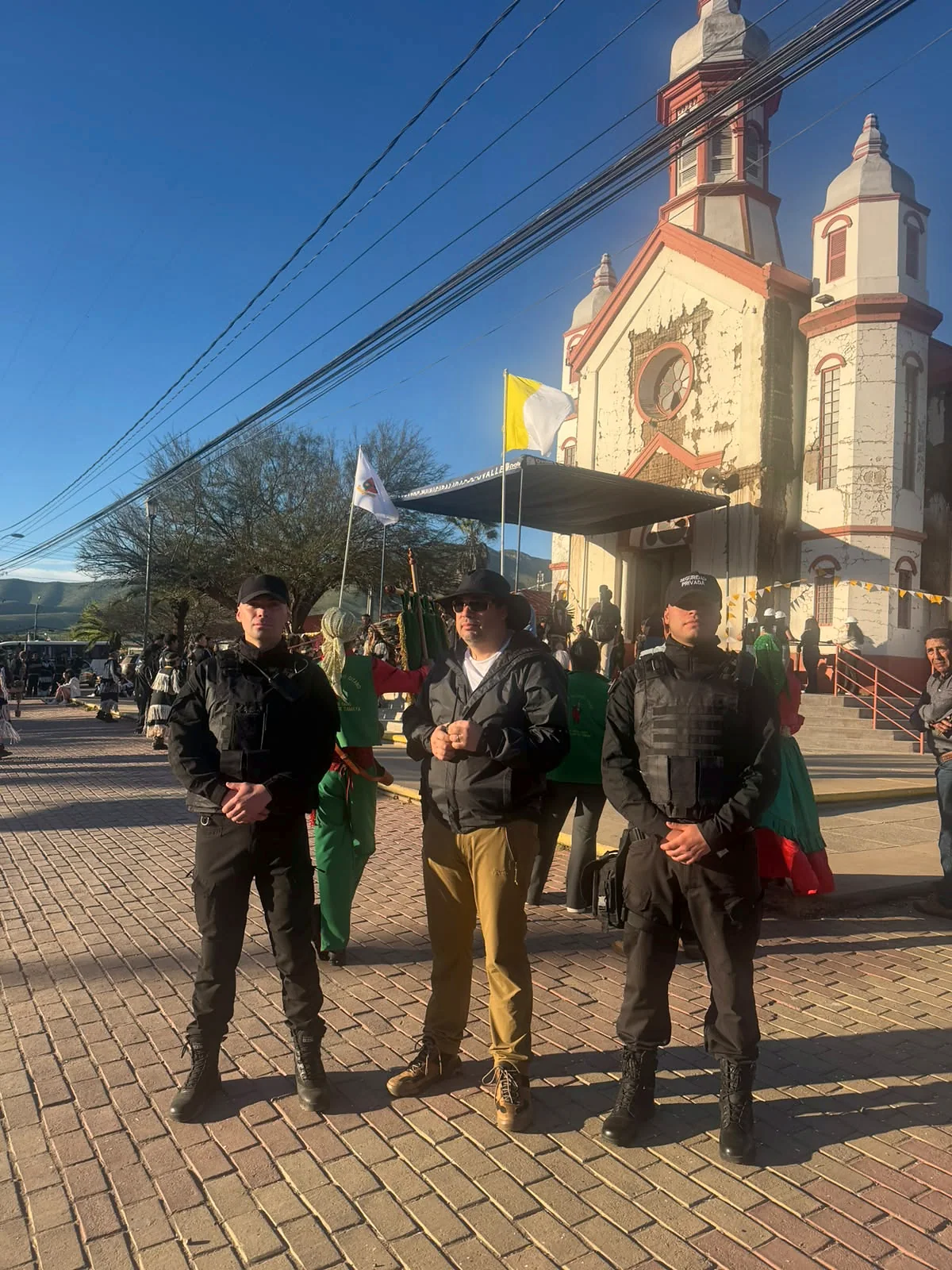 Dos guardias junto a un acompañante frente a un edificio religioso