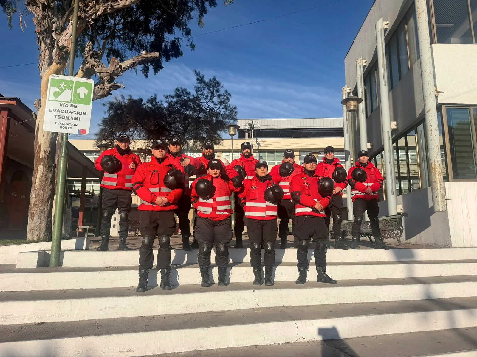 Grupo de guardias en uniforme rojo y negro sobre escalones de edificio público