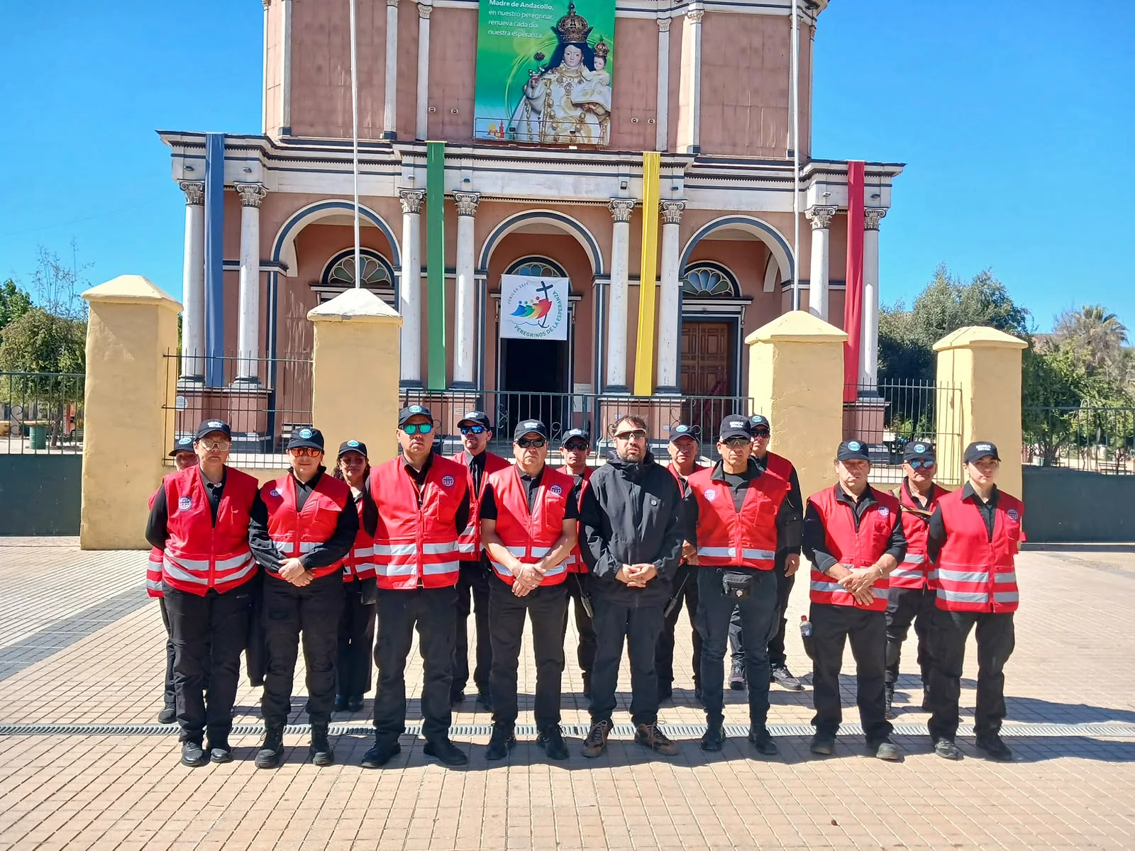 Grupo de guardias con chalecos rojos frente a edificio histórico