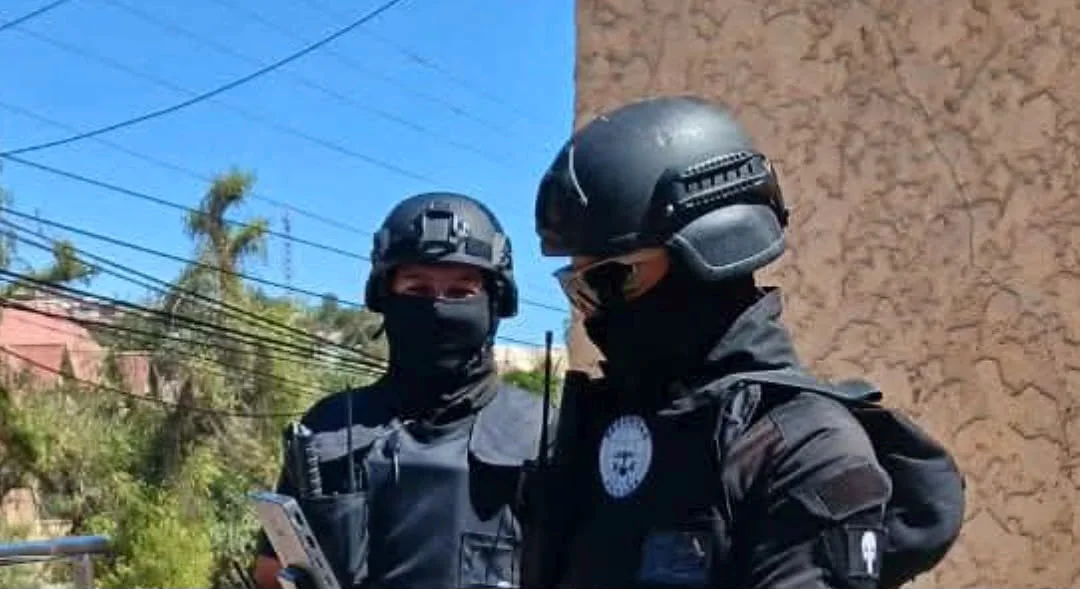 Dos agentes de seguridad con cascos negros y protección facial en área exterior